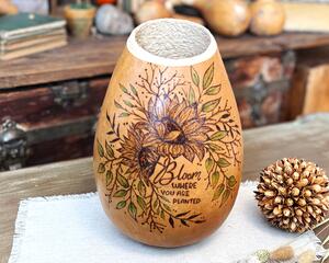 A gourd vase with sunflowers burned on the front and the inspirational phrase "bloom where you are planted".